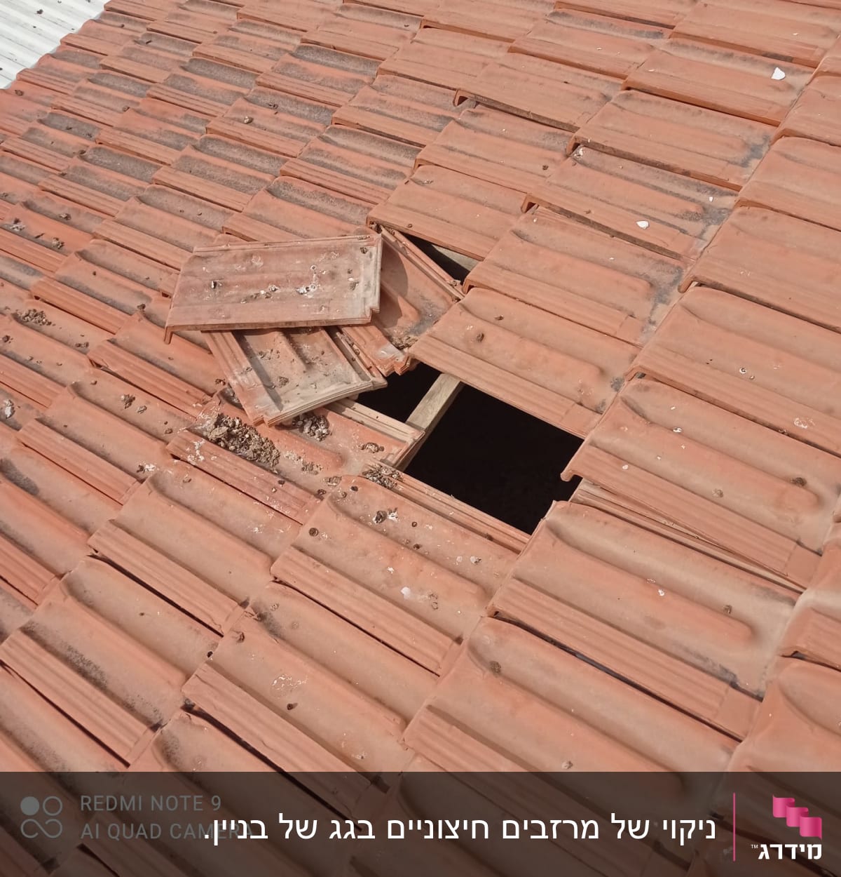 רעפים שבורים על גג עם חור חשוף